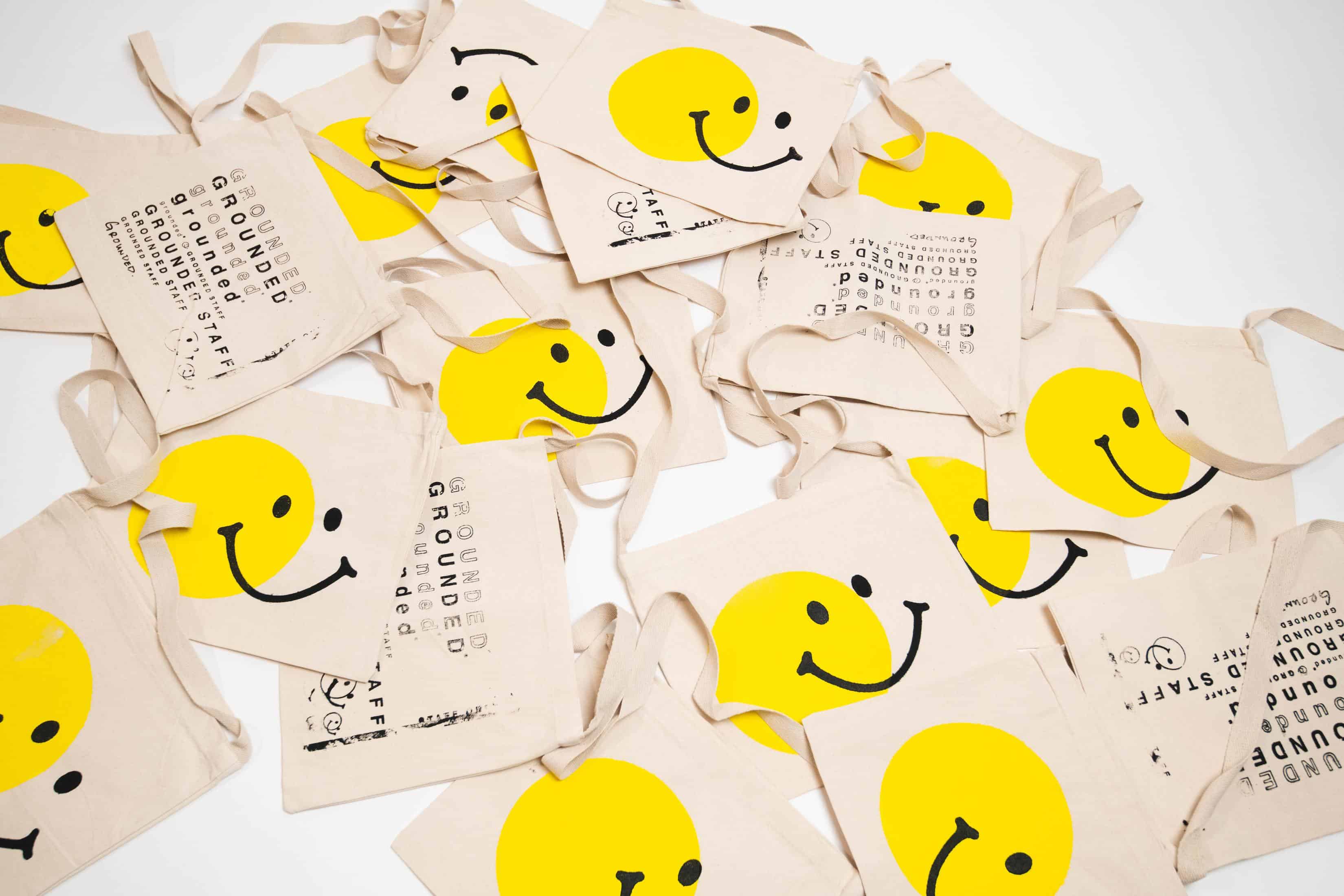 Tote bags with smiley faces and text