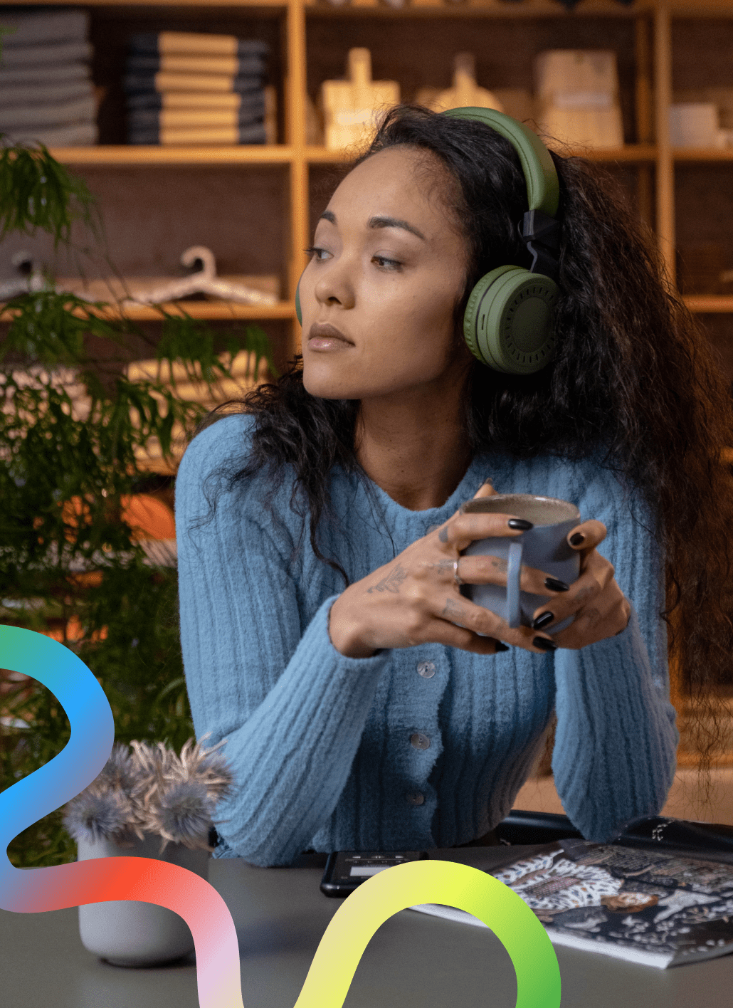 Girl with headphones on holding a mug
