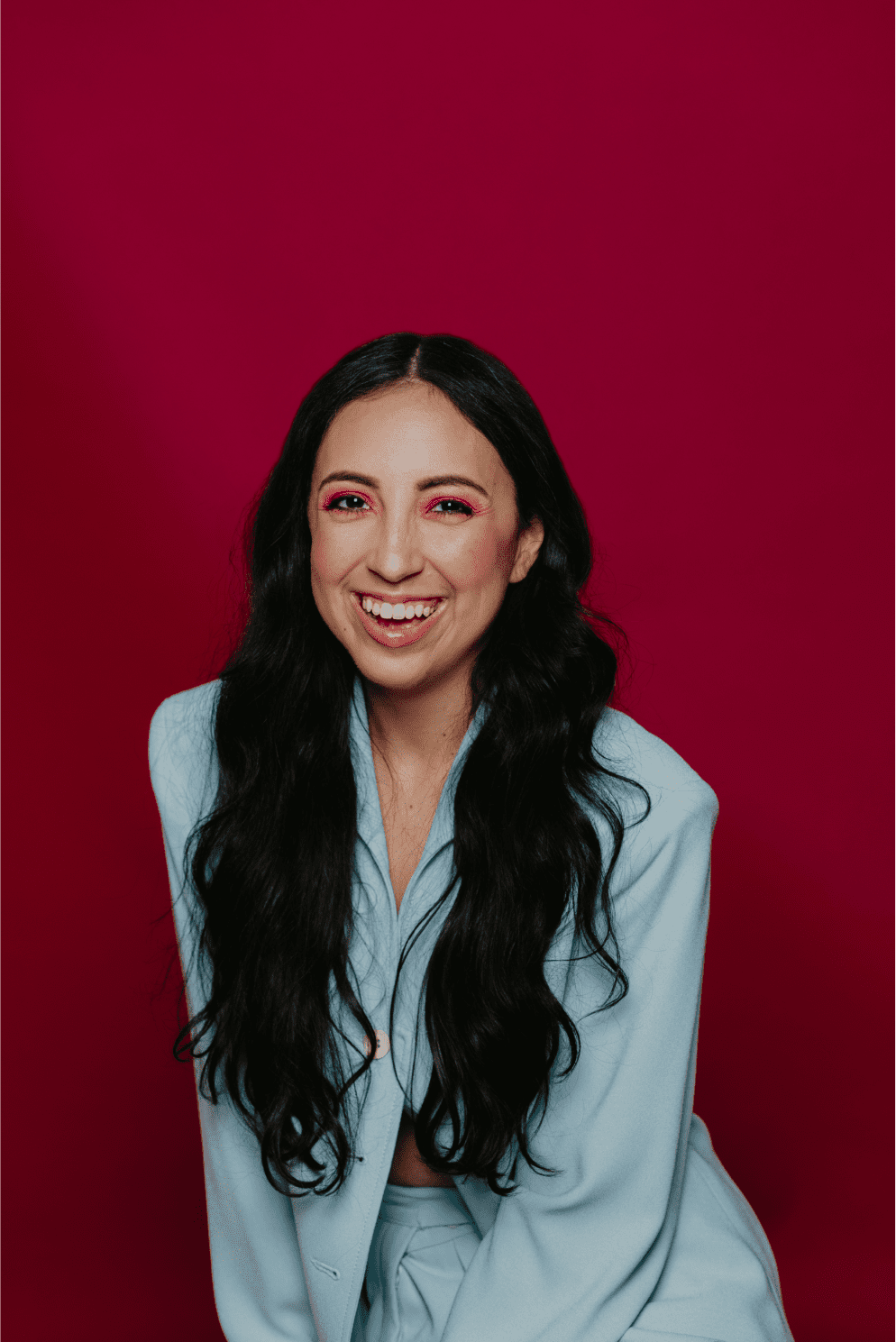 Creator Lissette Calveiro smiling headshot with red backdrop