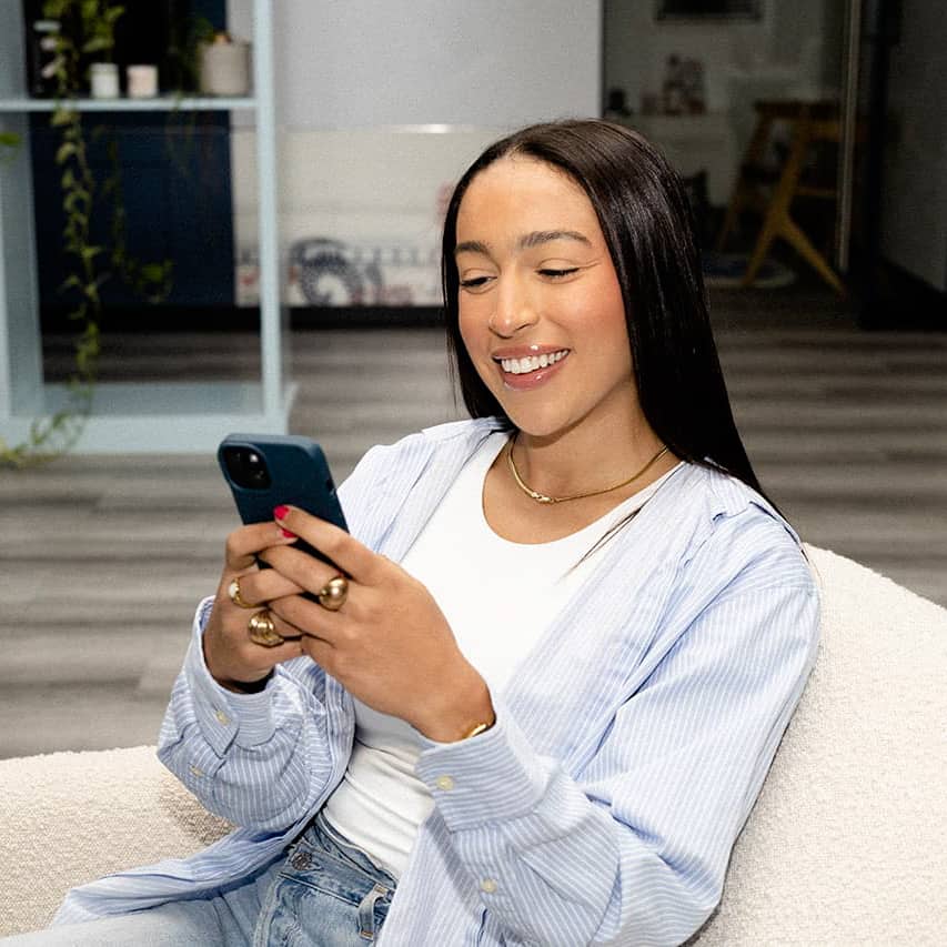 about page section powered by thinkific woman with phone on couch